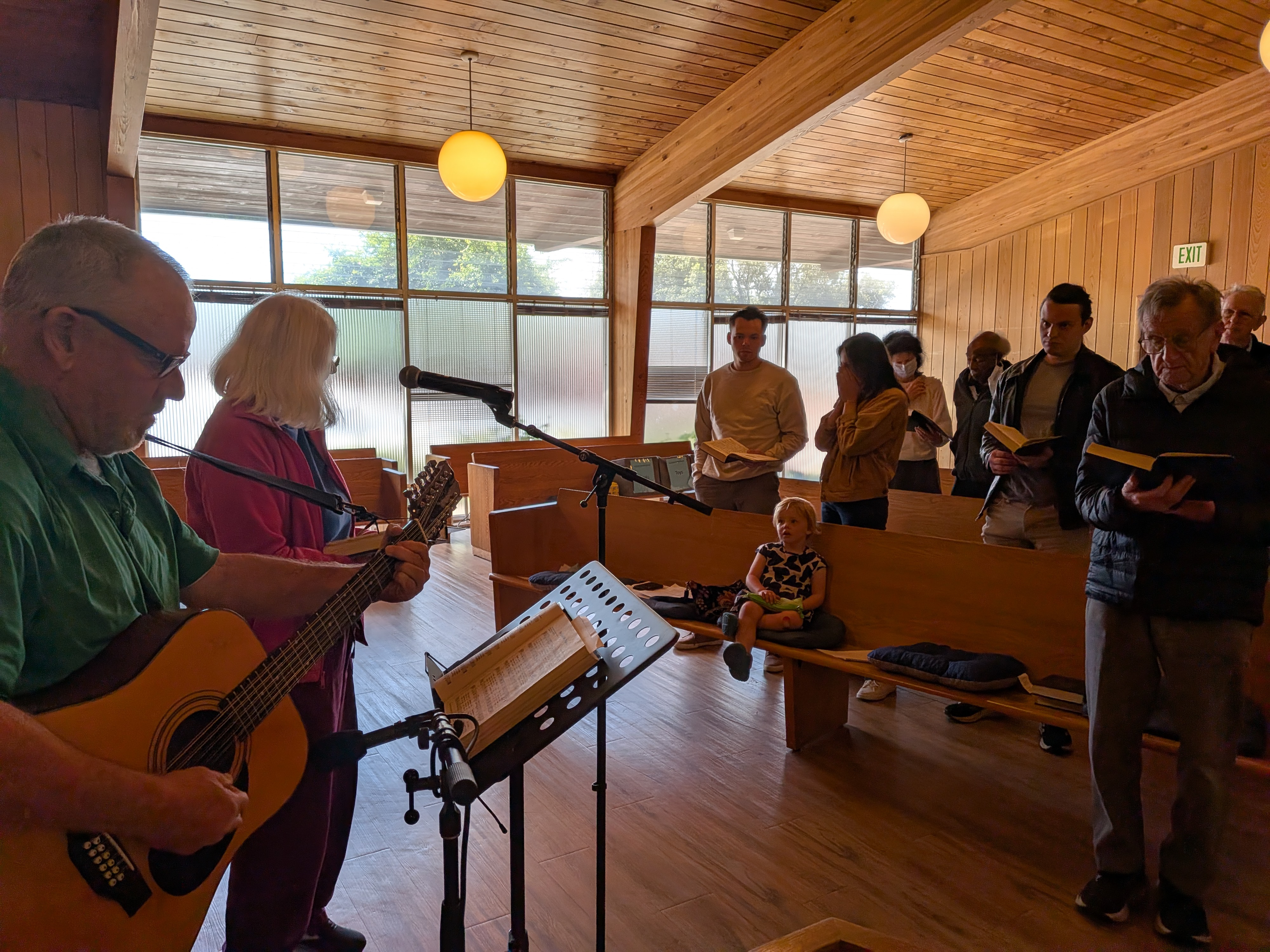 Congregation gathered in worship, with guitar music and open hymnals